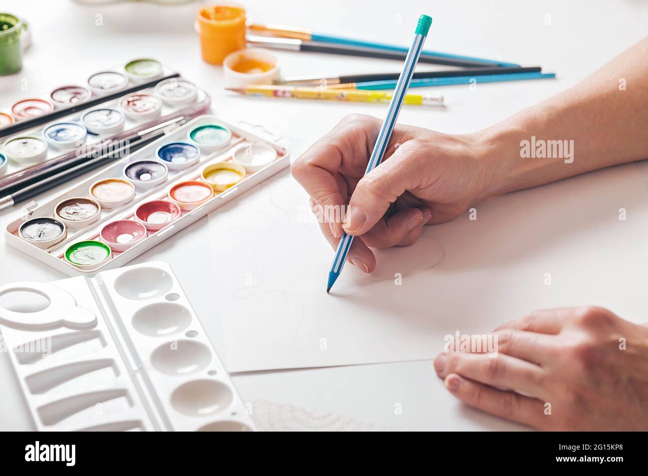 Graceful female hands sketching on a blank sheet of paper. Hands in the frame close-up. Hobbies concept. Stock Photo