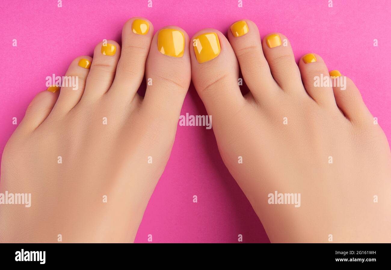 womans feet with spring summer nail design on pink background body treatment 2G161WH