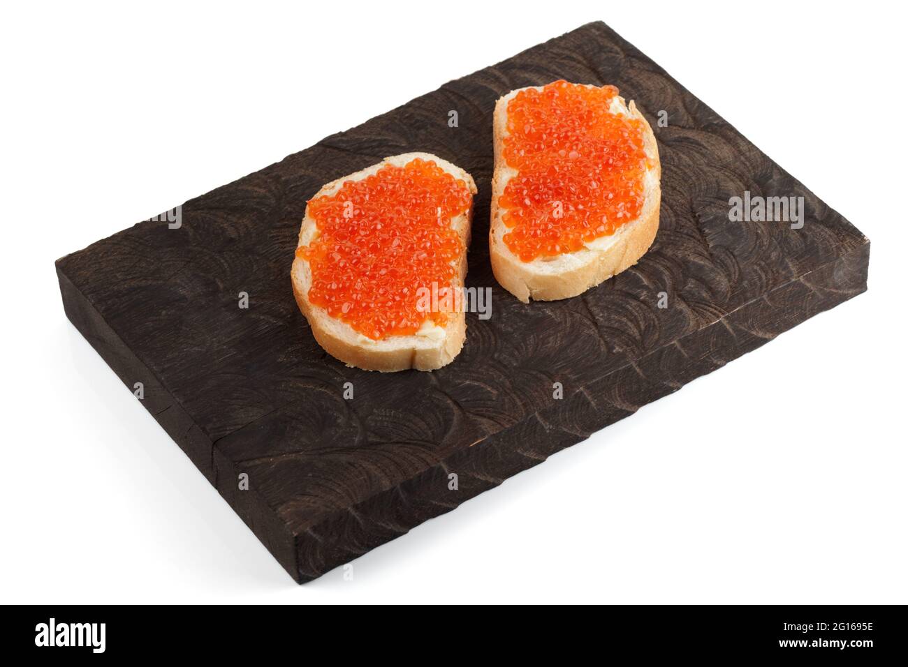 Open-face sandwiches with salmon roe on wooden board, isolated on white background Stock Photo