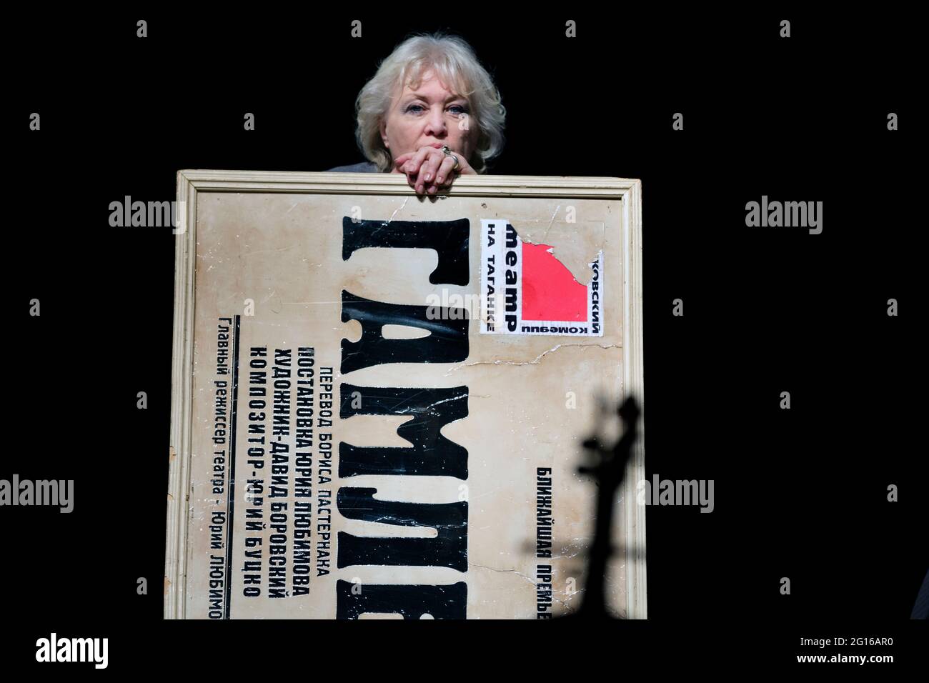 Moscow, Russia. 22nd of April, 2014 The honoured artist of Russia Tatiana Sidorenko during the performance of the Taganka theatre 'Taganka front' to the 50th anniversary of the theater in Moscow, Russia. She holds an old banner of the famous play 'Hamlet' with the name of the performance and the theater logo Stock Photo