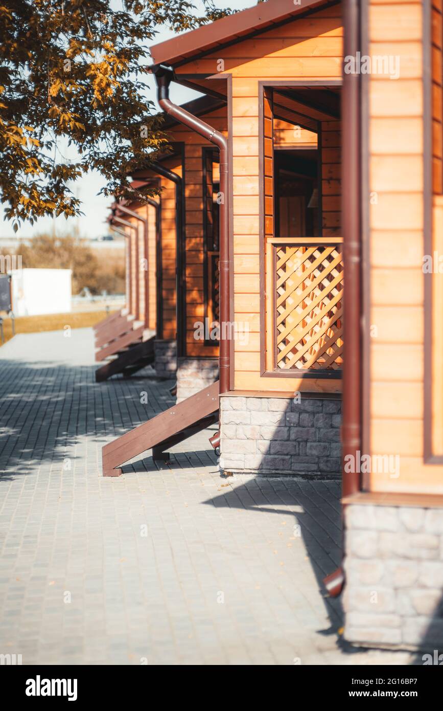 An alleyway with trees on the left and the row of equal wooden summer ...
