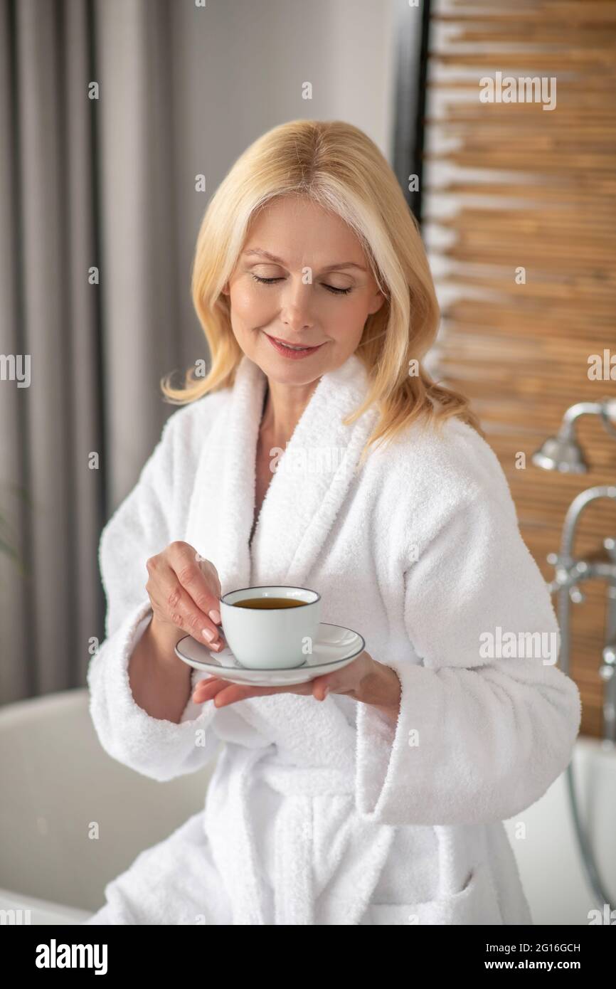 Woman Having Tea Good-looking blonde woman having tea and looking balanced Stock Photo ...