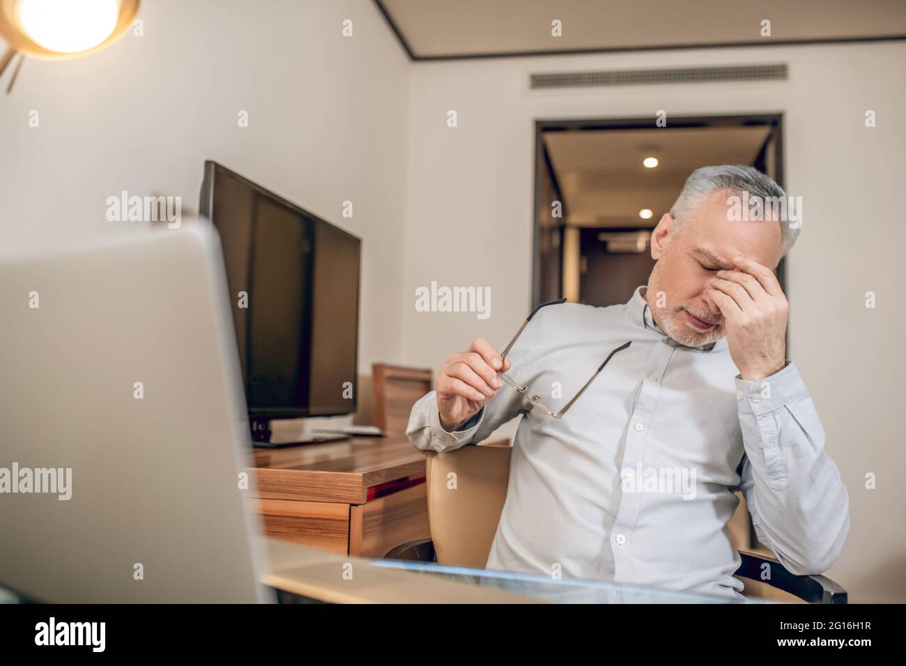 Gray-haired man feeling tired after a long working day Stock Photo - Alamy