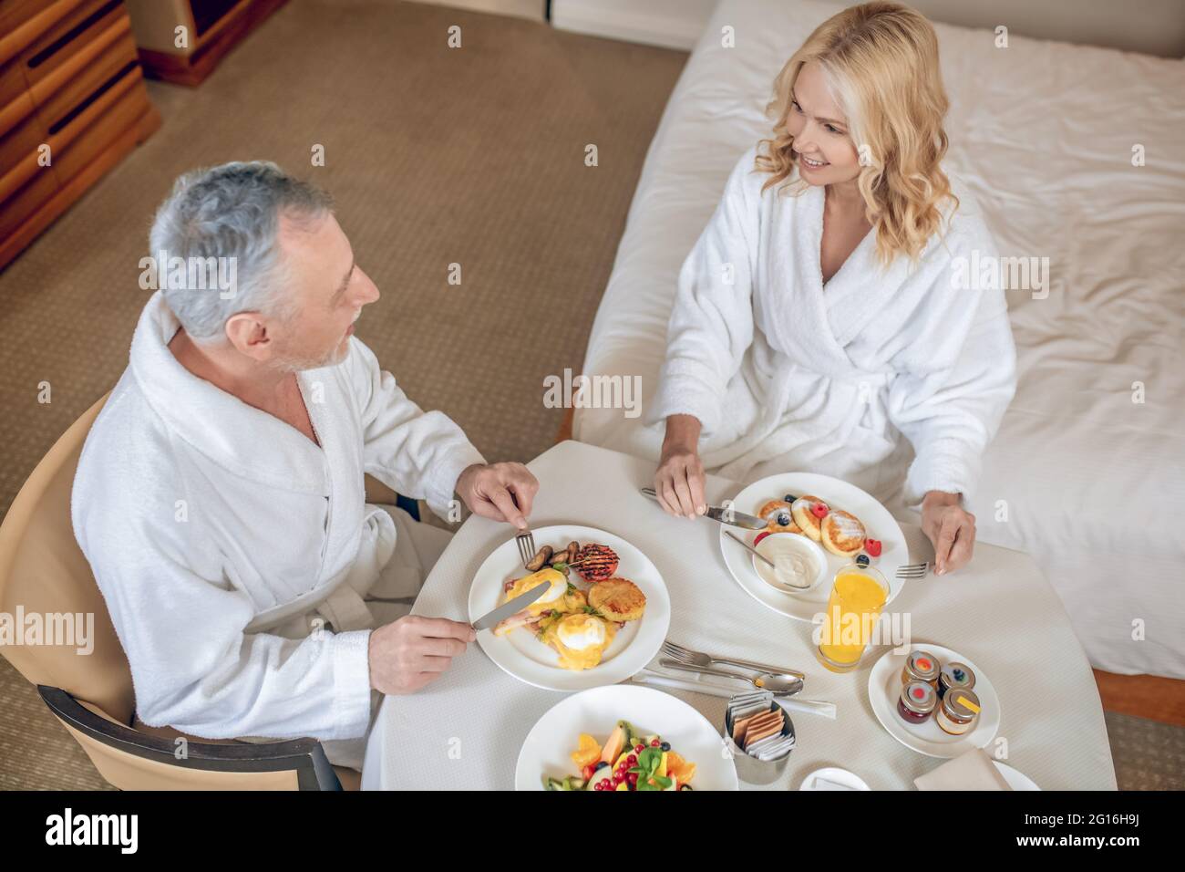 Breakfast In Robe A couple in white robes having breakfast and looking pleased Stock ...
