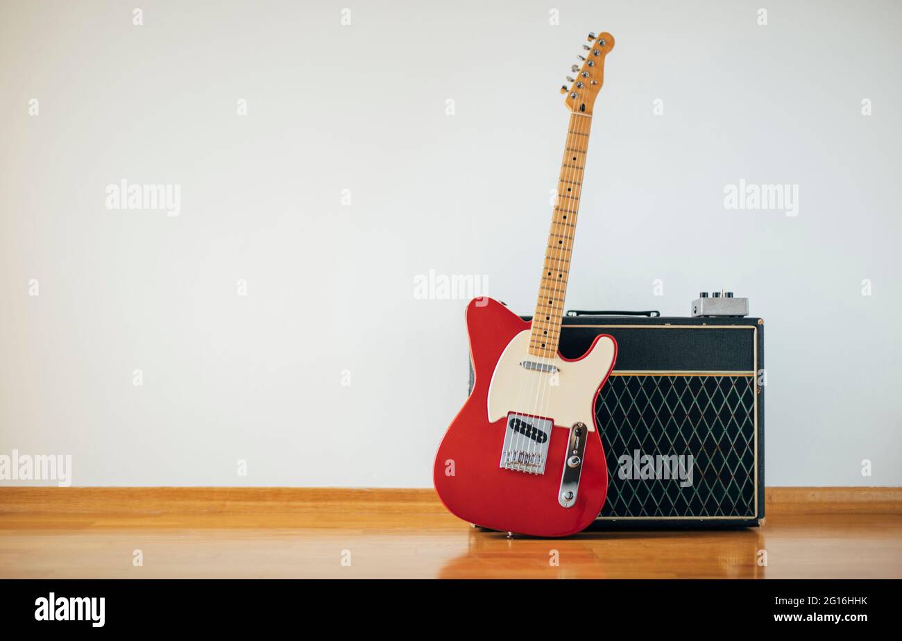 Red electric guitar on white wall background, copy space Stock Photo