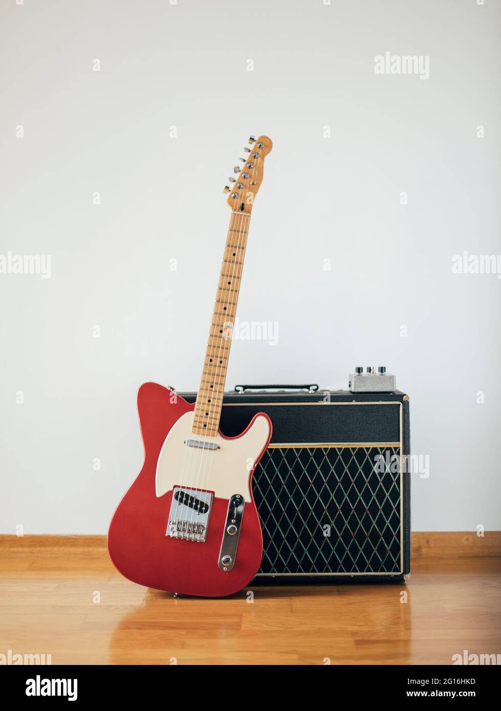 Red electric guitar on white wall Stock Photo