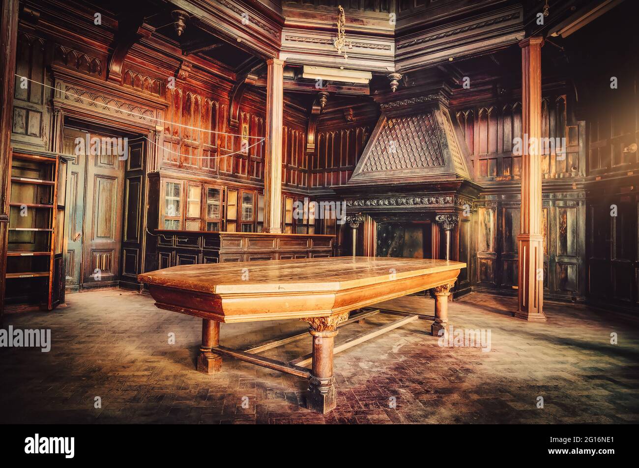 Antique hall with fireplace and table in an ancient building Stock Photo