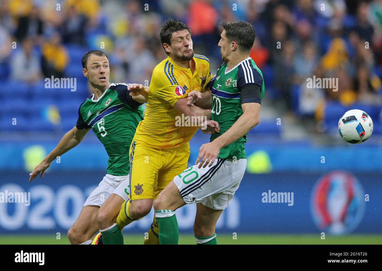 LYON, FRANCE - JUNE 16, 2016: Yevhen Seleznyov of Ukraine (C) fights for a ball with Jonny Evans (L) and Craig Cathcart of Northern Ireland during their UEFA EURO 2016 game at Stade de Lyon stadium Stock Photo