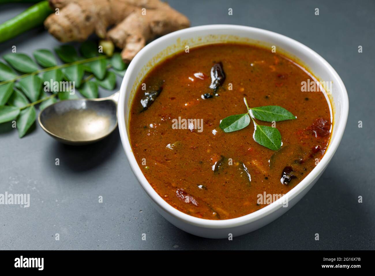 Inji puli or Puli Inji Kerala traditional feast side dish made using tamarind ,ginger and green chilli arranged in a white table ware with grey colour Stock Photo