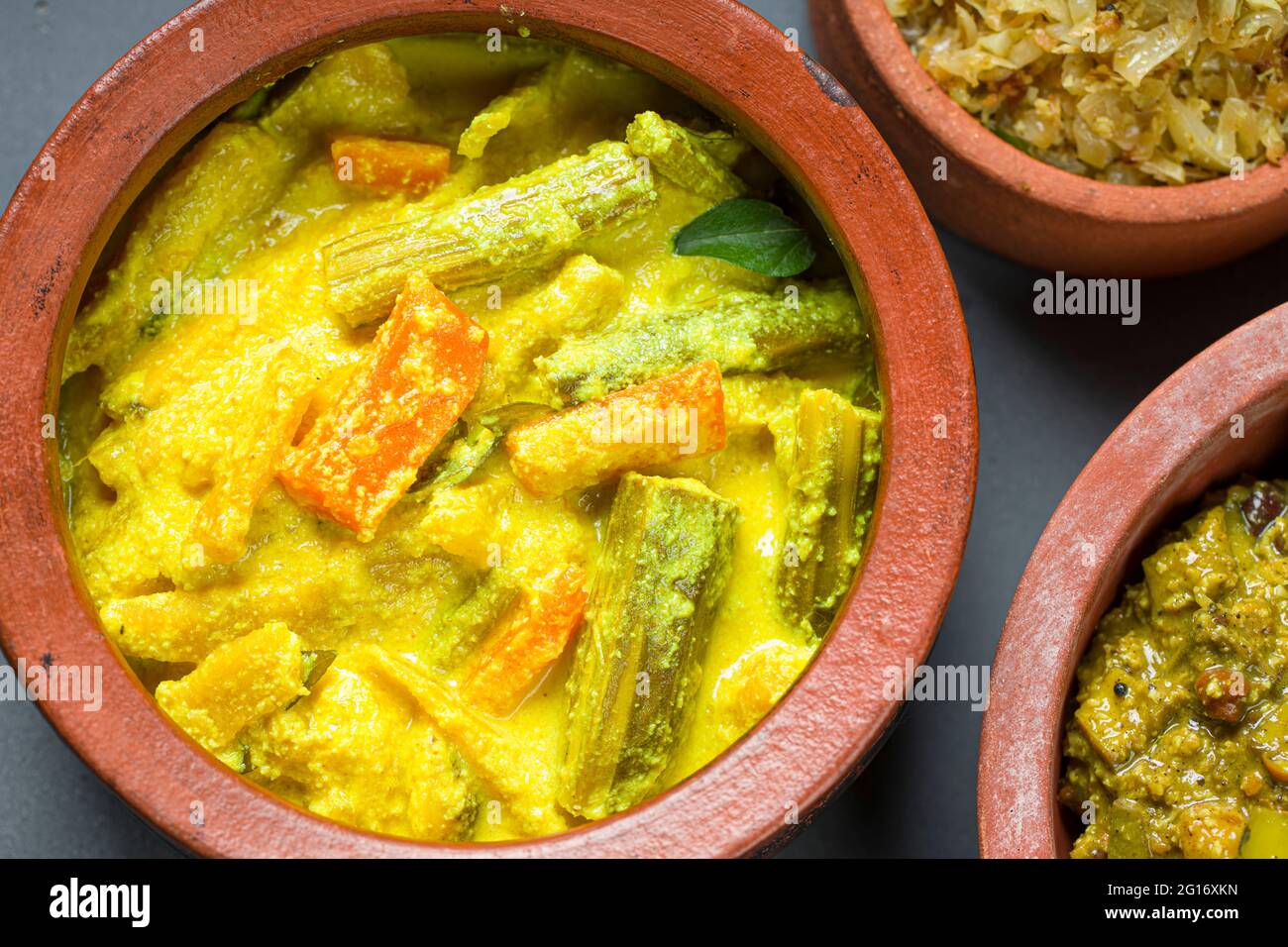 Avial,Kootu curry and Cabbage fry Kerala traditional  side dishes which  is very healthy and tasty vegeterian  dishes ,arranged in an earthenwares wit Stock Photo