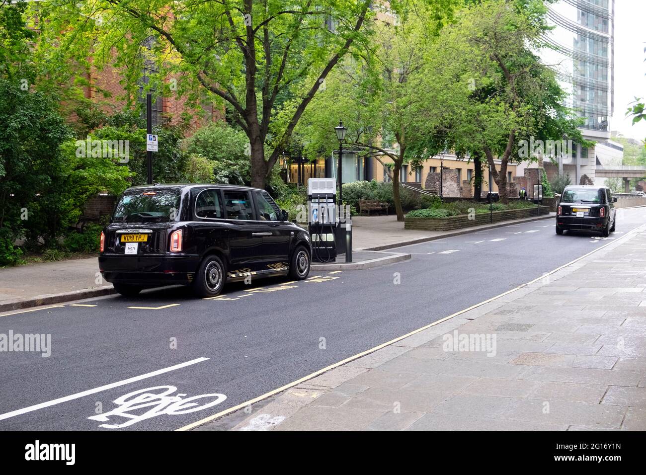 Black London taxi cab electric charging station juice point on road in the City of London England UK  KATHY DEWITT Stock Photo