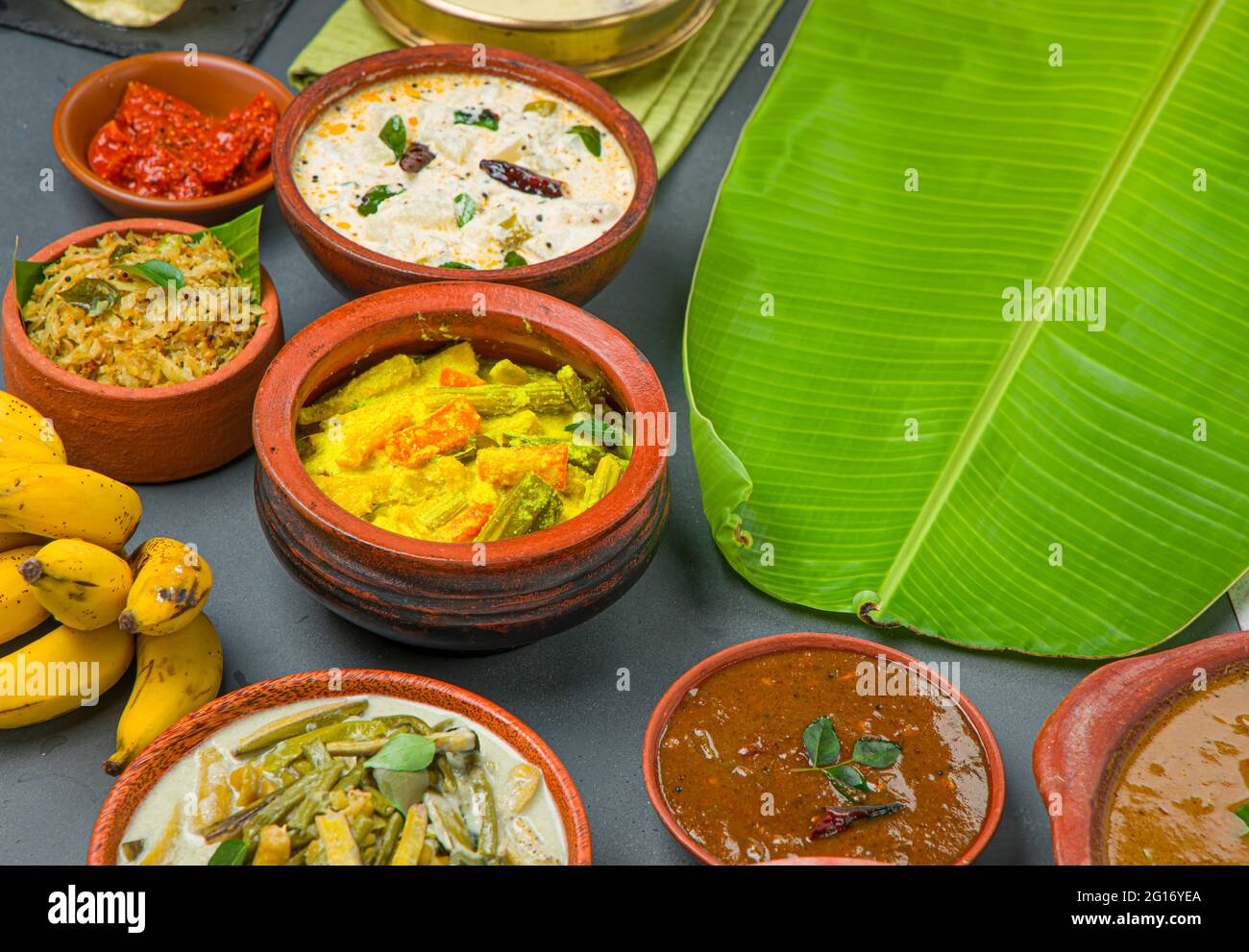 Kerala traditional feast side dishes arranged  in a two colour background with banana leaf ,for serving food. Stock Photo