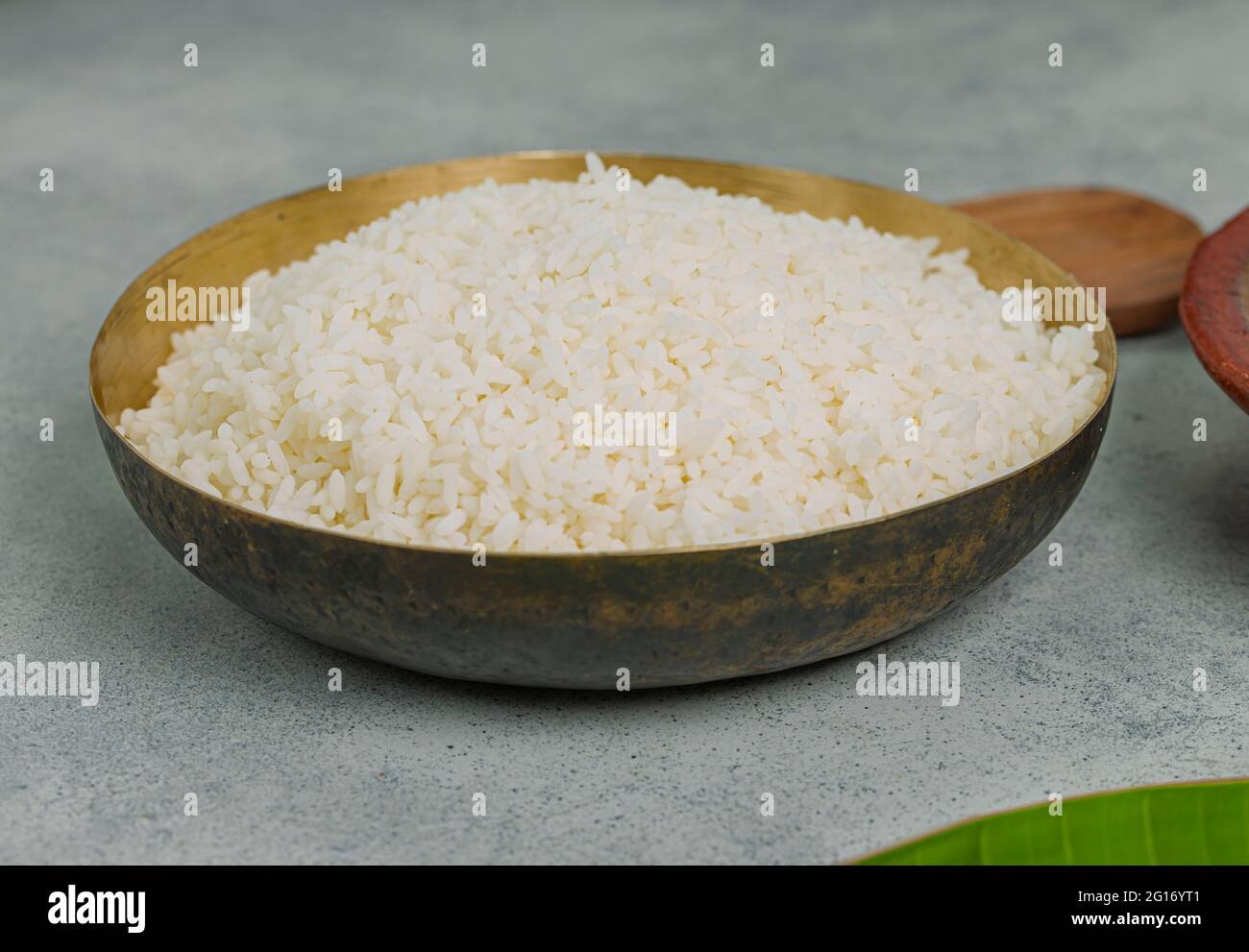Cooked rice arranged in a brass vessel with grey colour background ...