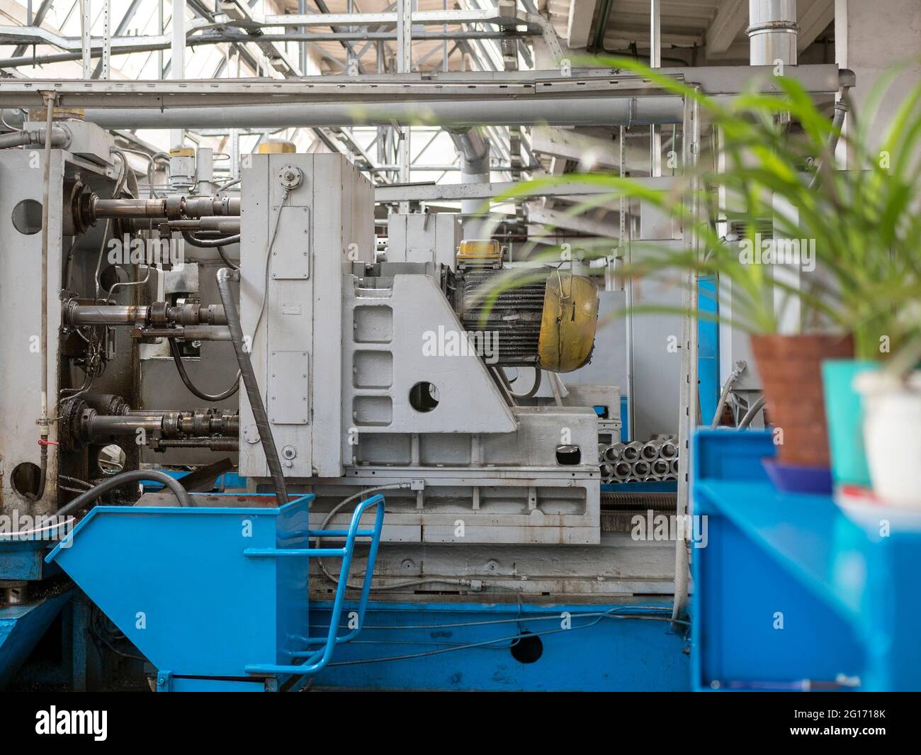 View of the shop for the production of machine parts with old equipment and pot plants. Production hall Stock Photo