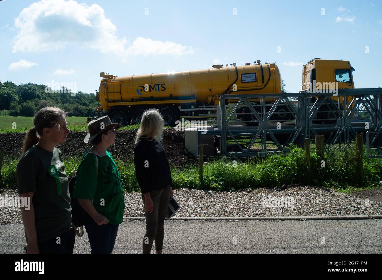 Chalfont St Giles, UK. 5th June, 2021. Another HGV trundles along the HS2 haul road. Carolyne Culver (left) standing for Amersham and Chesham by-election met local residents impacted by the High Speed Rail construction today. HS2 have built a steep and high sided haul road right outside residents homes in Bottom House Farm Lane, Chalfont St Giles.  The noise, disruption and impact is unbearable for some residents. Credit: Maureen McLean/Alamy Live News Stock Photo