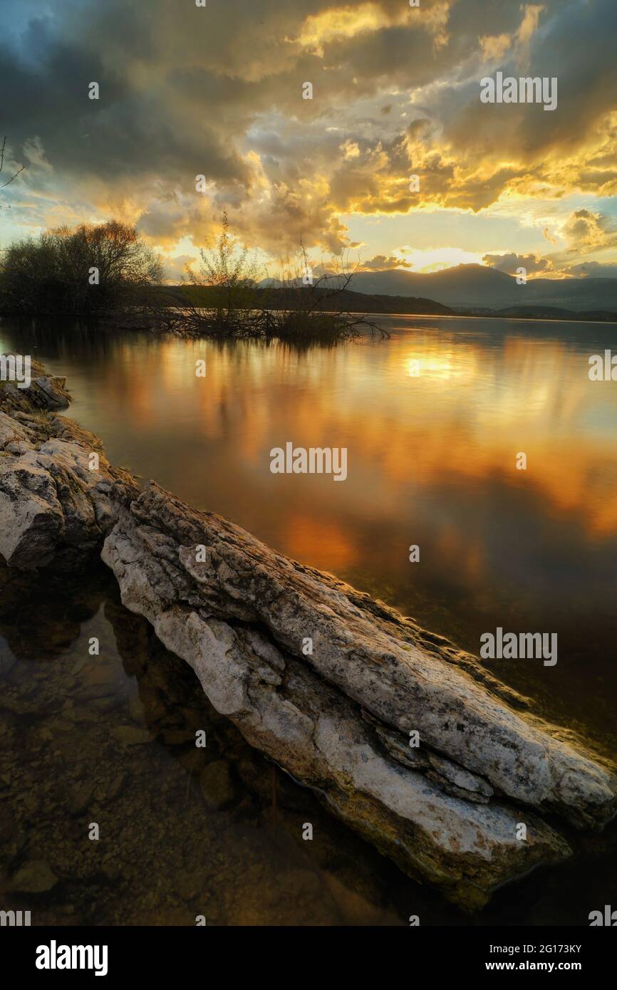 Vertical shot of a lake reflecting the cloudy sky during sunset Stock ...