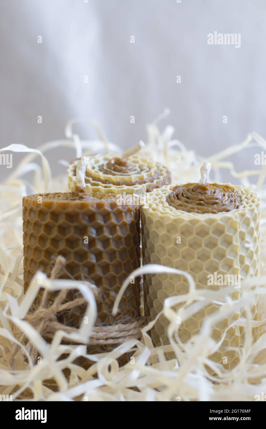 Wax honey candles in wood shavings. Decorations for the interior Stock