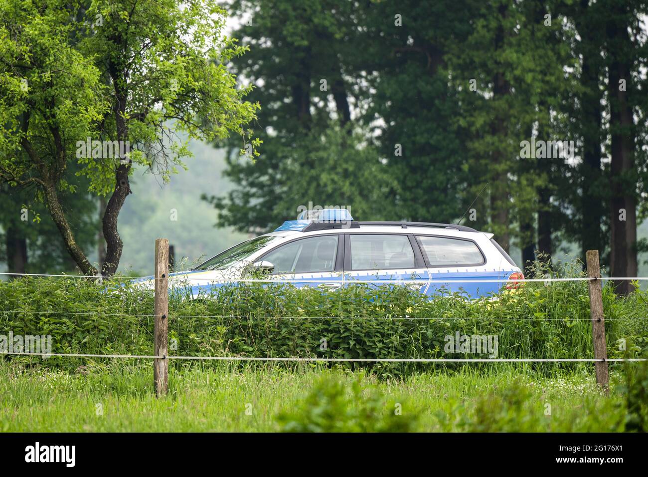 Rastede, Germany. 05th June, 2021. A police vehicle is on the sidelines of the meeting against the construction of the A20 motorway in front of a wooded area. Credit: Mohssen Assanimoghaddam/dpa/Alamy Live News Stock Photo