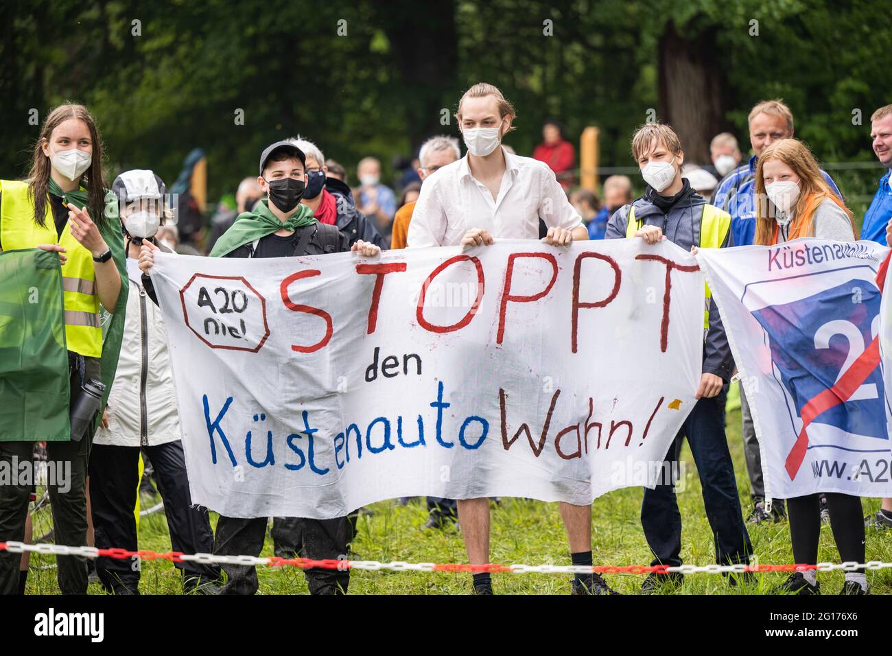 Rastede, Germany. 05th June, 2021. Some demonstrators at a meeting against the construction of the A20 motorway hold a banner with the inscription 'A20 nie! Stop the coastal car mania'. Credit: Mohssen Assanimoghaddam/dpa/Alamy Live News Stock Photo