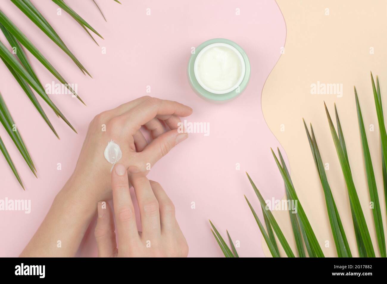 A woman applies moisturizer to hands. Organic cosmetics for skin care. Beauty concept Stock Photo