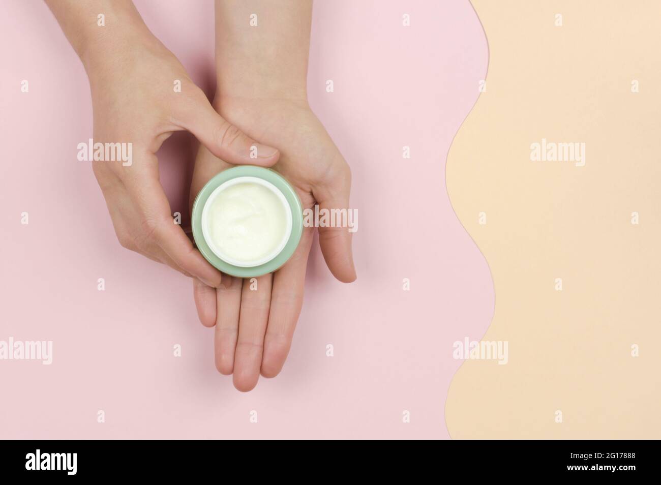 An open jar of cream in a woman's hand. Organic cosmetics for skin care. Beauty concept Stock Photo