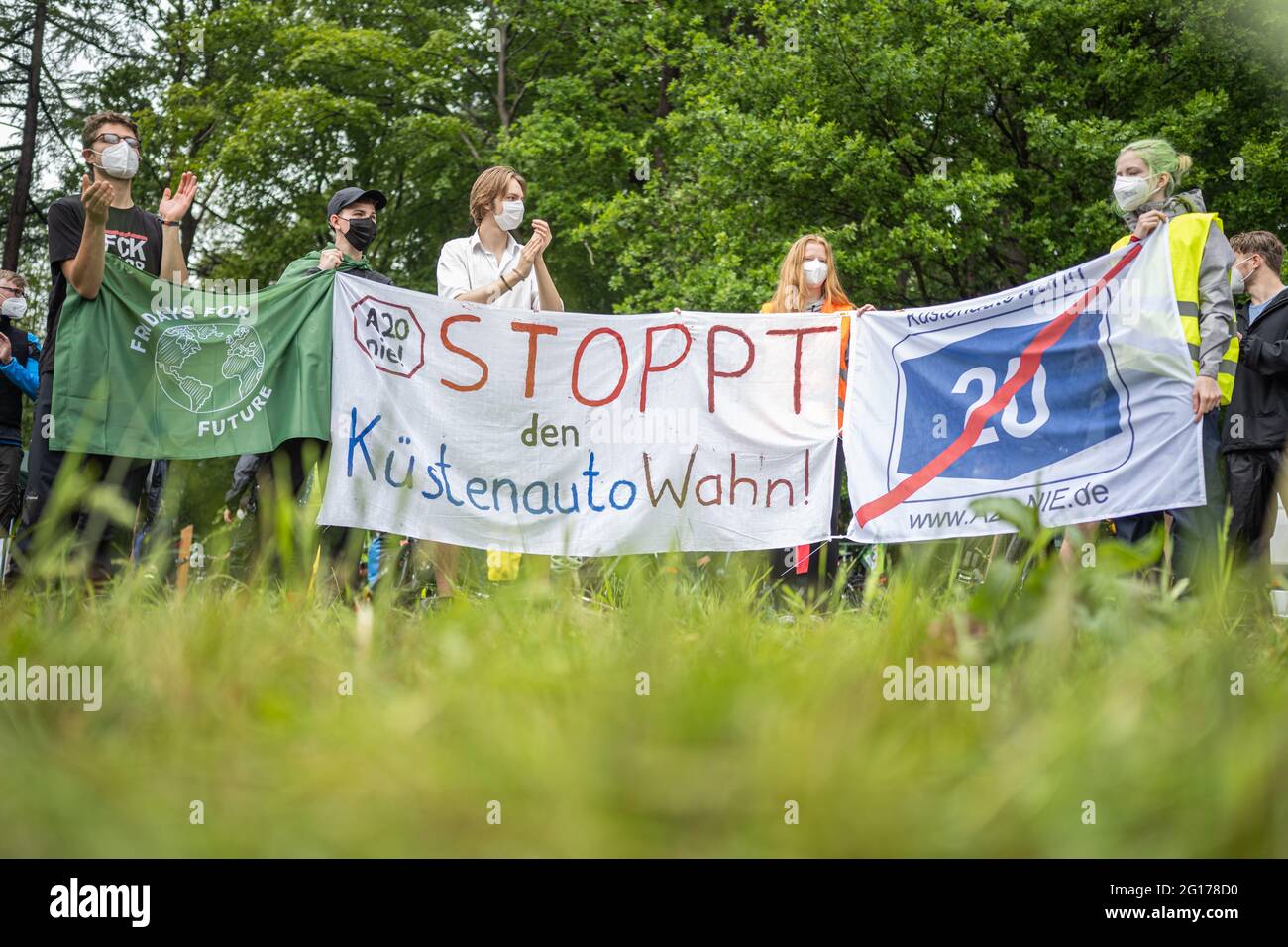 Rastede, Germany. 05th June, 2021. Some demonstrators at a meeting against the construction of the A20 motorway hold banners with the inscriptions 'Fridays for Future' and 'A20 nie! Stop the coastal car mania!' and 'A20 crossed out'. Credit: Mohssen Assanimoghaddam/dpa/Alamy Live News Stock Photo