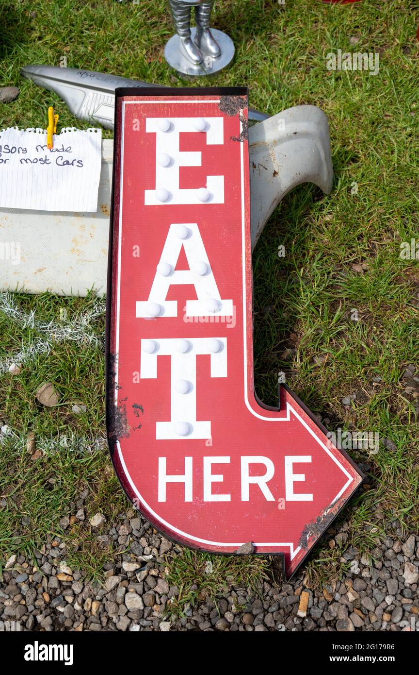 Restaurant sign reading “ Eat Here” in white on a red background for sale at a classic car show in Norfolk Stock Photo