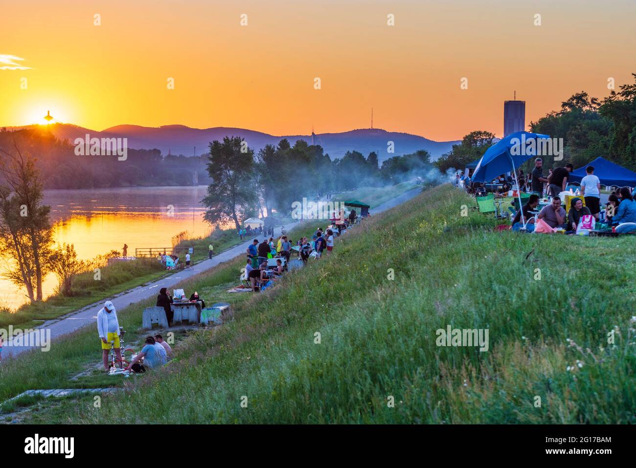 Wien, Vienna sunset at river Neue Donau (New Danube), barbecue zone, people grill meat, view to