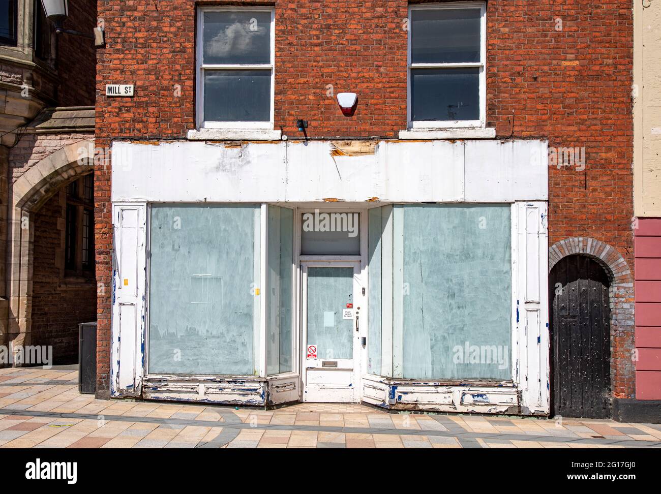 Closed down shop with white washed windows in town centre of Congleton Cheshire UK Stock Photo