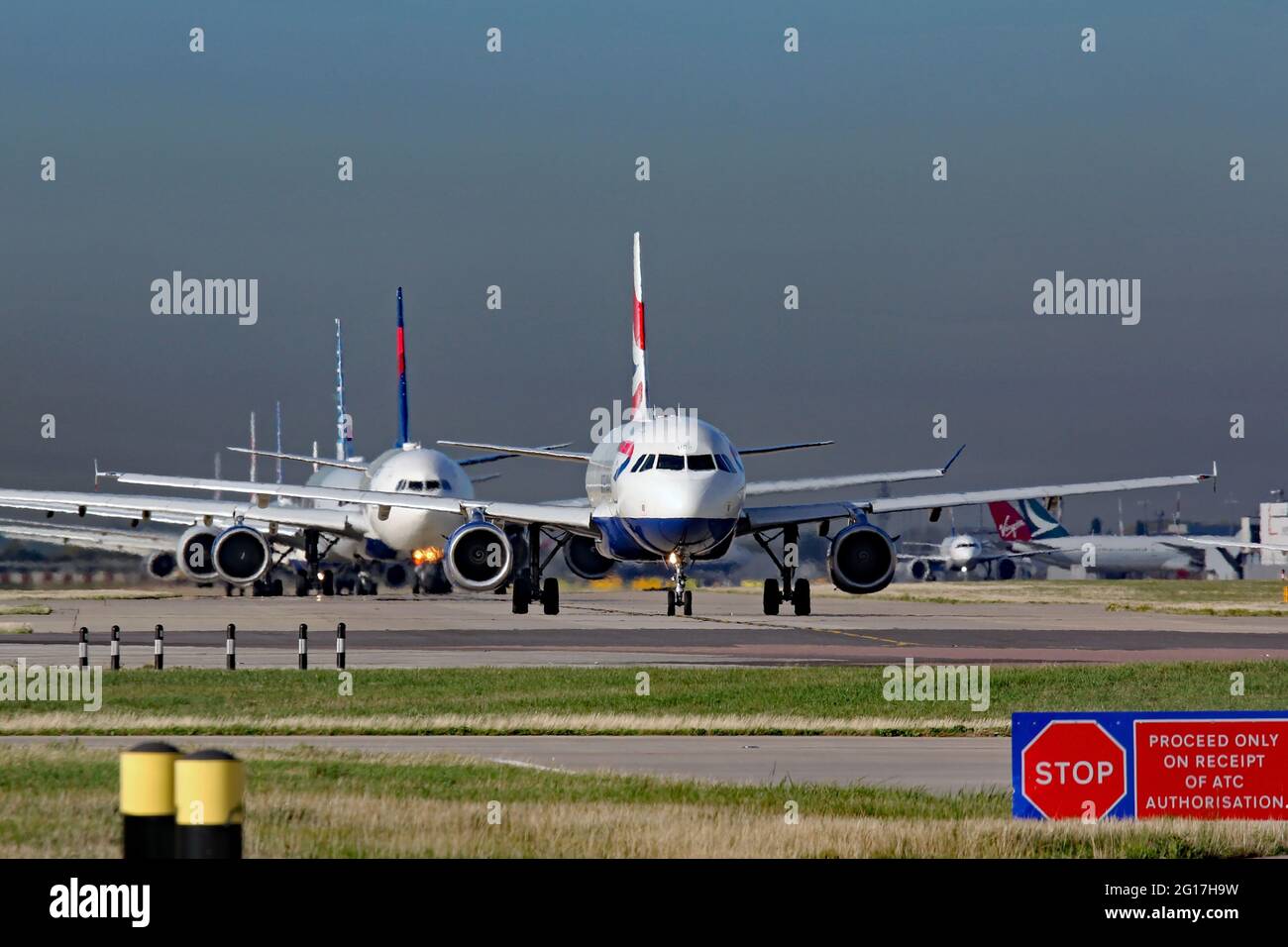 A queue of aircraft waiting for take-off at Heathrow airport Stock Photo