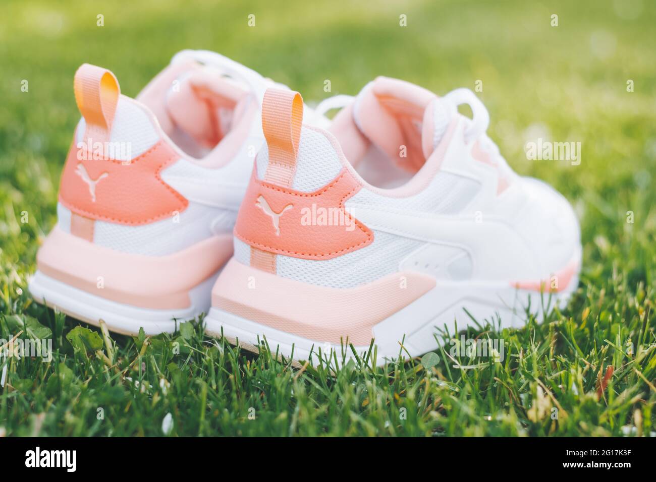 Minsk, Belarus, 23.05.2021: White women's PUMA sneakers with coral inserts  stand on grass in rays of sunlight Stock Photo - Alamy