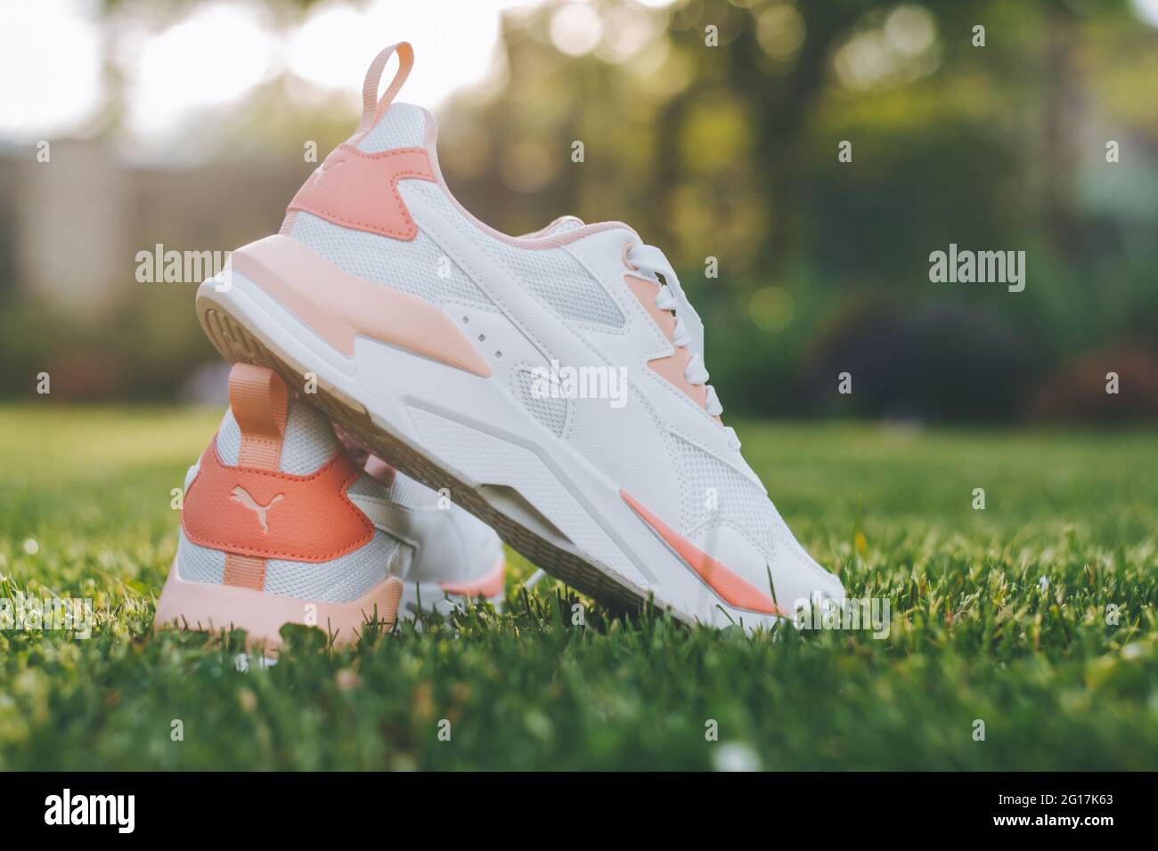 Minsk, Belarus, 23.05.2021: White women's PUMA sneakers with coral inserts  stand on grass in rays of sunlight Stock Photo - Alamy