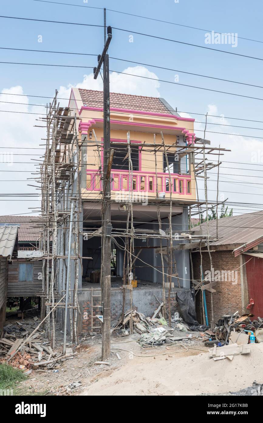 House construction with wooden scaffolding poles, Paksong, Laos Stock Photo