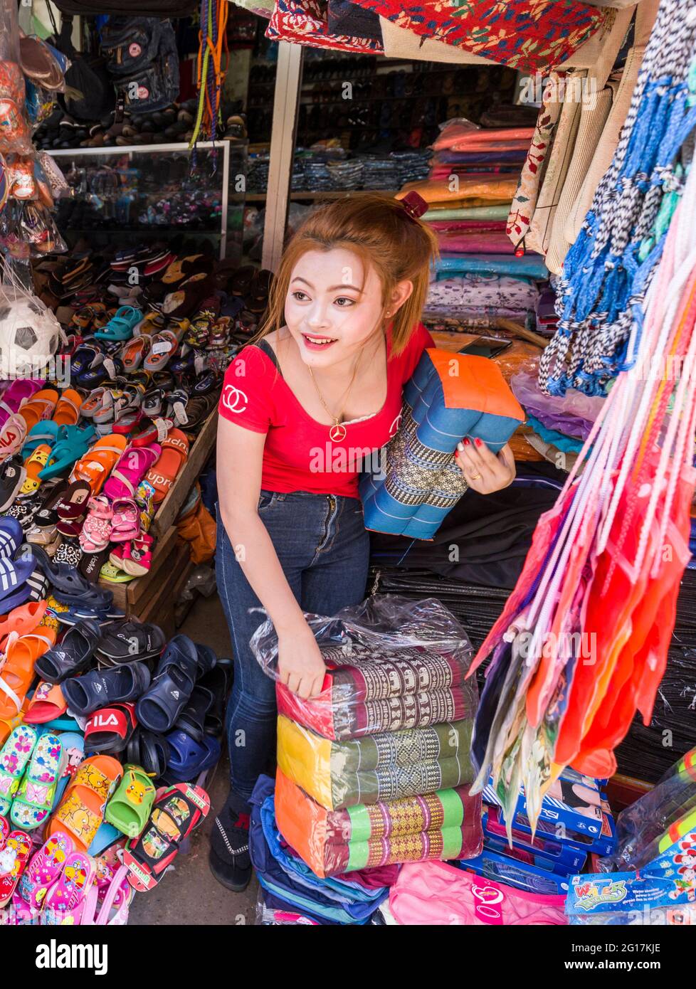 Girl unpacking footrests in market, Pakse, Laos Stock Photo