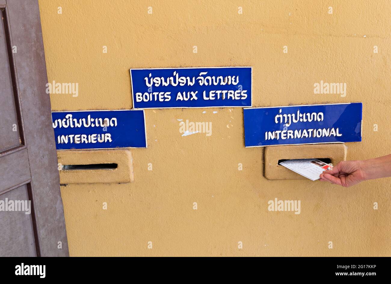 Posting postcards at post office with interior and international mail slots, Pakse, Laos Stock Photo