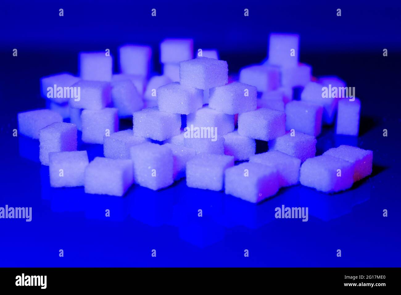 Sugar cubes in different arrangements and colored light. Arrows, Cubes, Pile, Square. Bavaria Germany Stock Photo