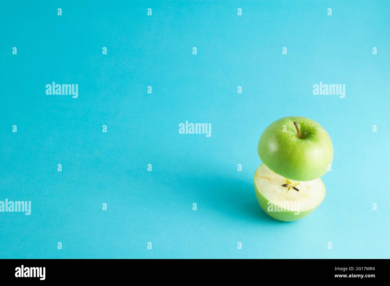 Fresh green apple with a half flying on blue background. Flying green ...