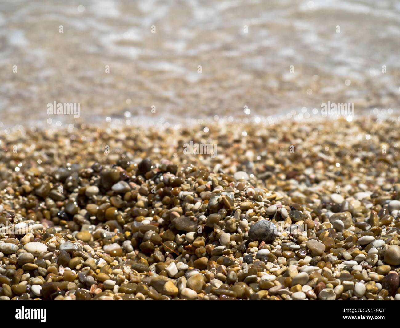 Clear water on a Pebble beach Stock Photo