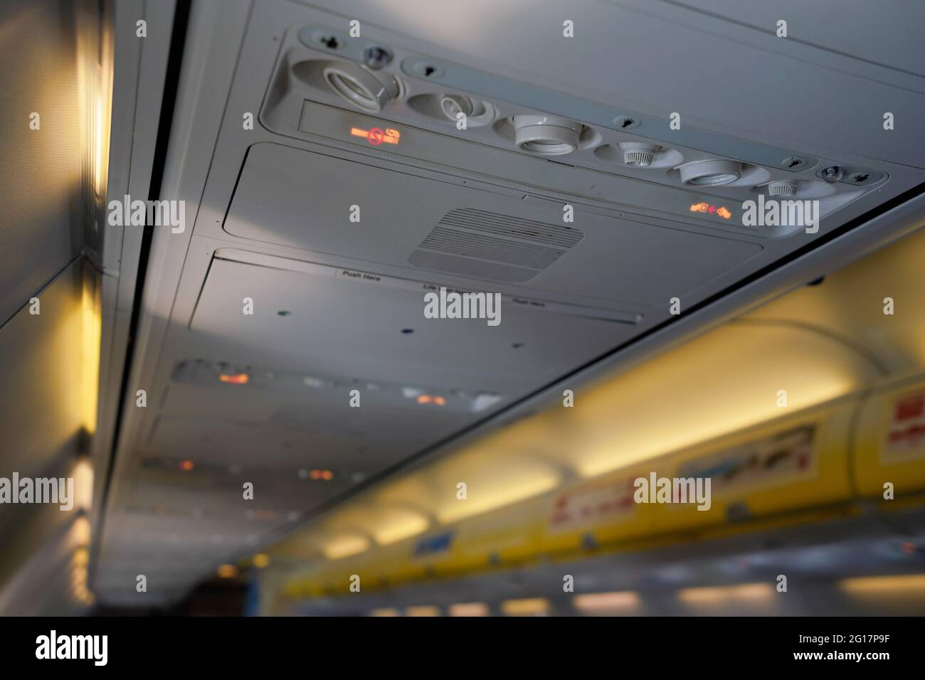 Air conditioning or ventilation knobs and reading light lamps above passenger seats in airplane