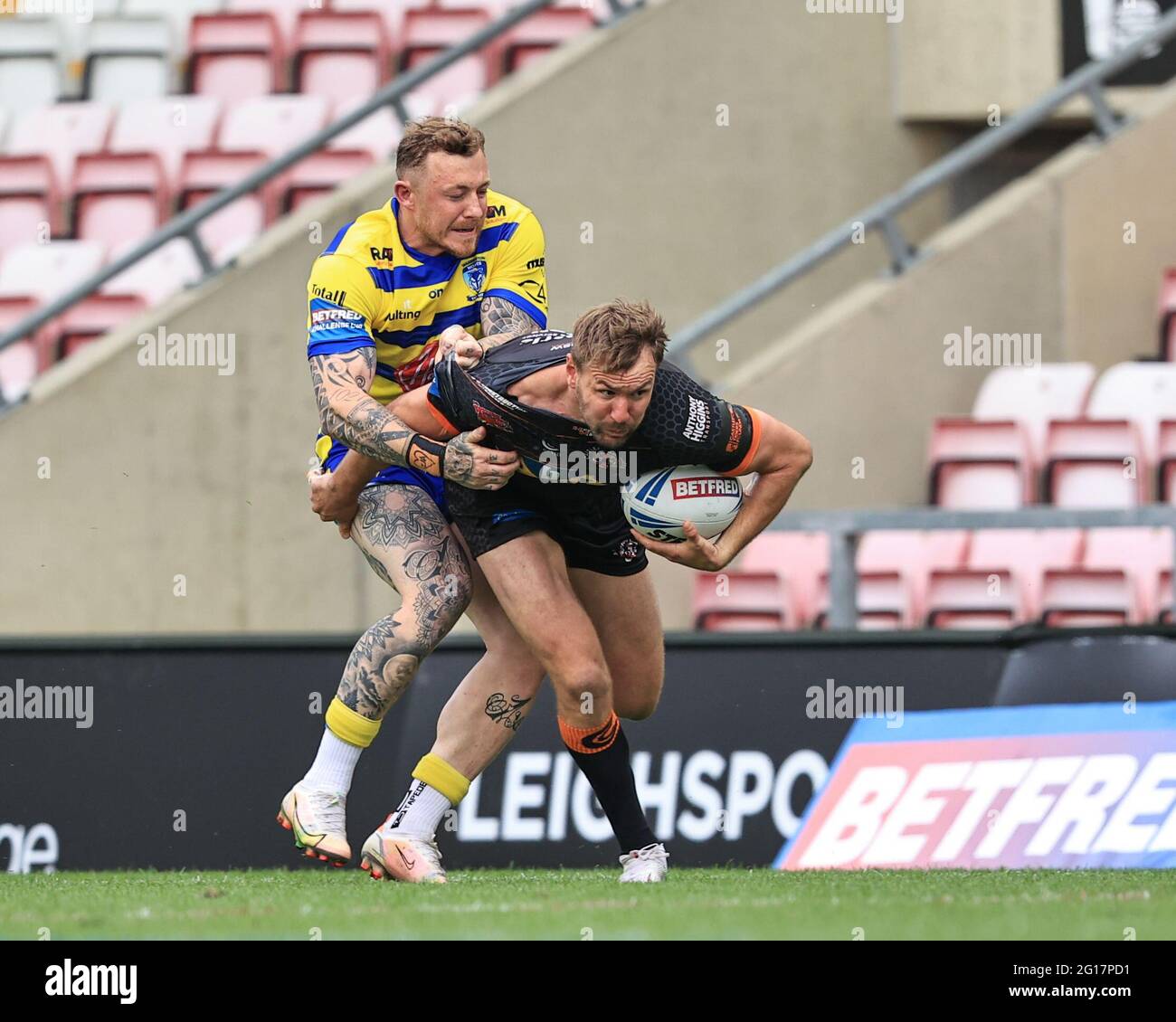 Michael Shenton (4) of Castleford Tigers busts the tackle of Josh