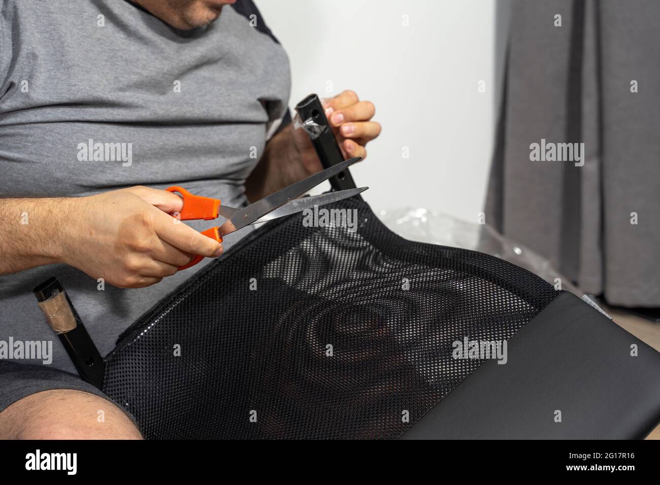 a man assembles a new chair at home. Stock Photo
