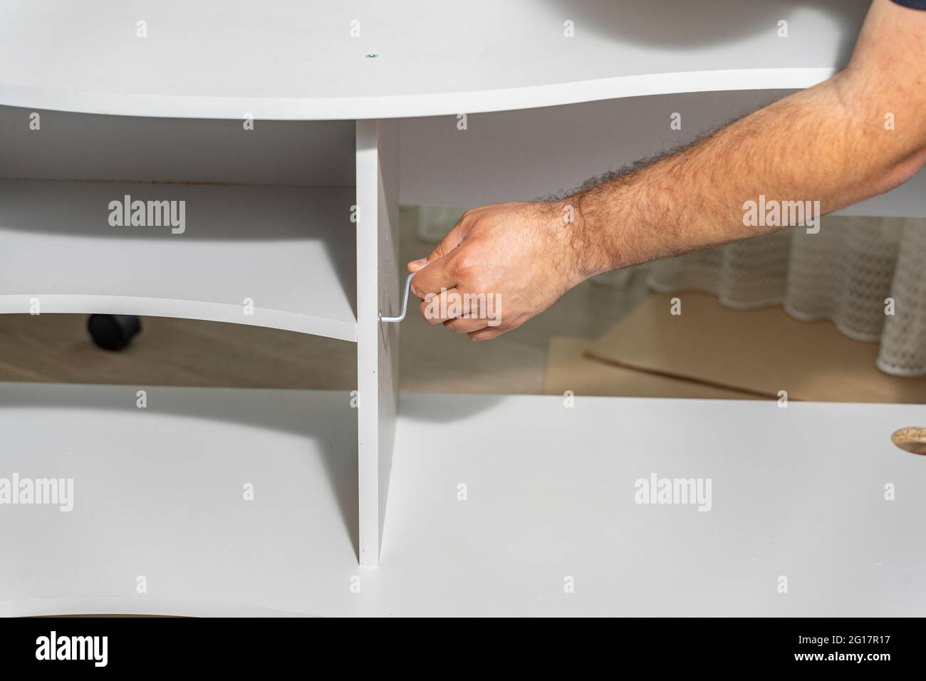 master assembles a new shelf at home Stock Photo