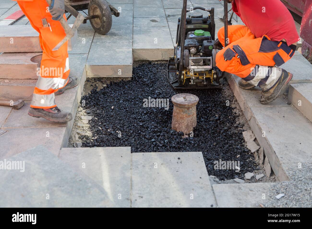 workers lay concrete blocks in the pedestrian zone Stock Photo