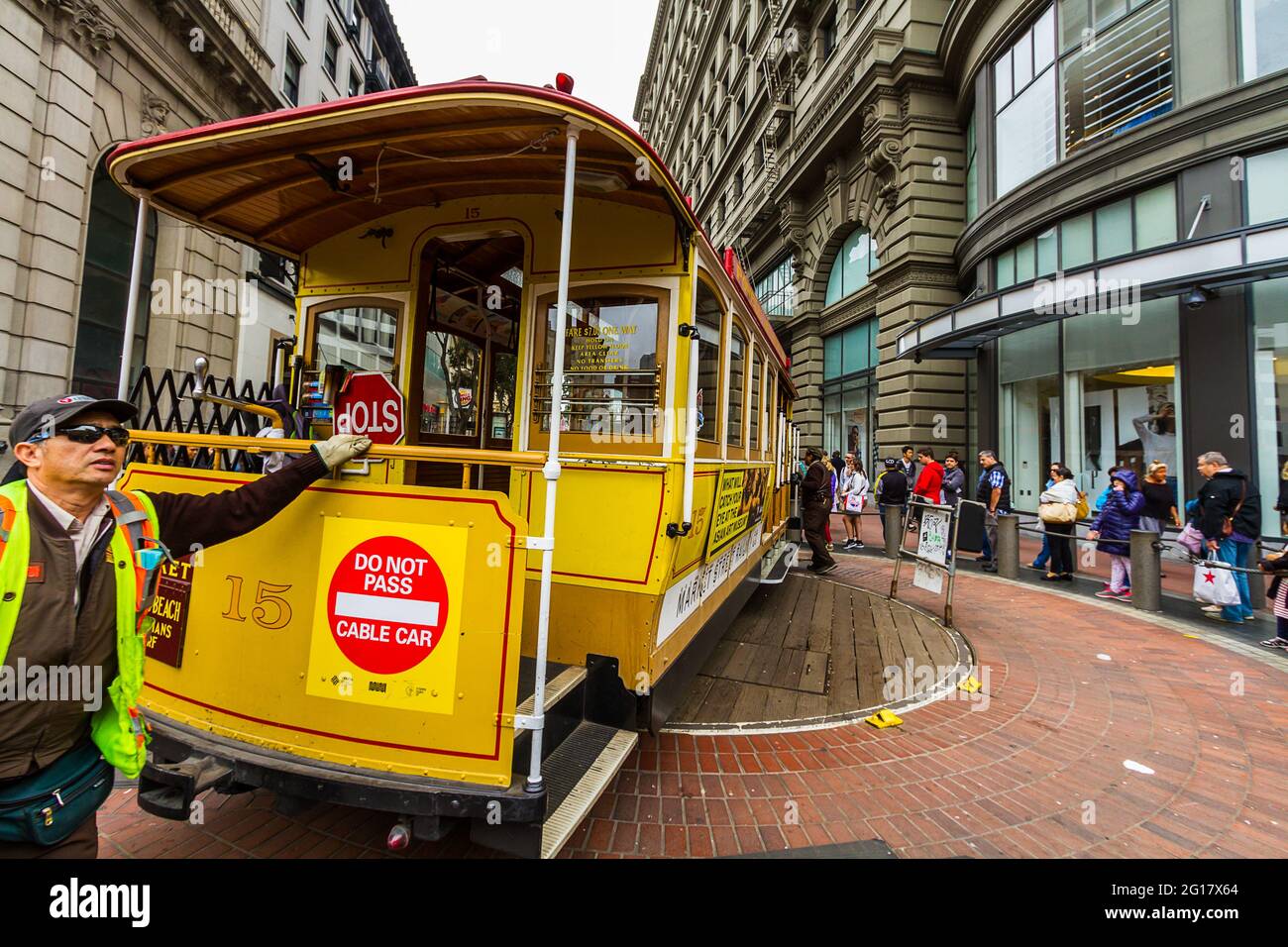People waiting in the line to take the cable car and a worker is rotating the cable car Stock Photo