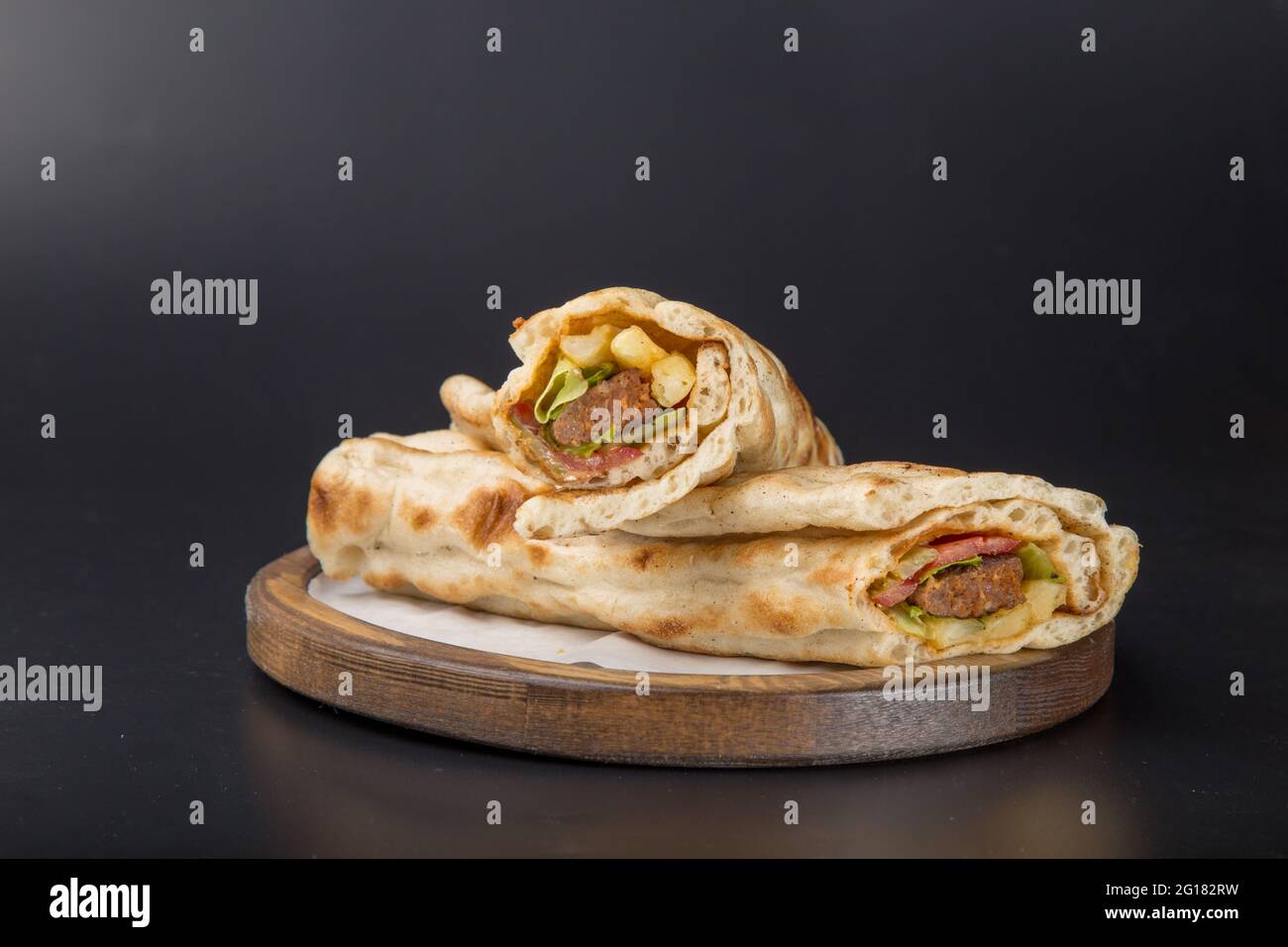 crispy chicken wrap fast food meat wood plate black back ground Stock