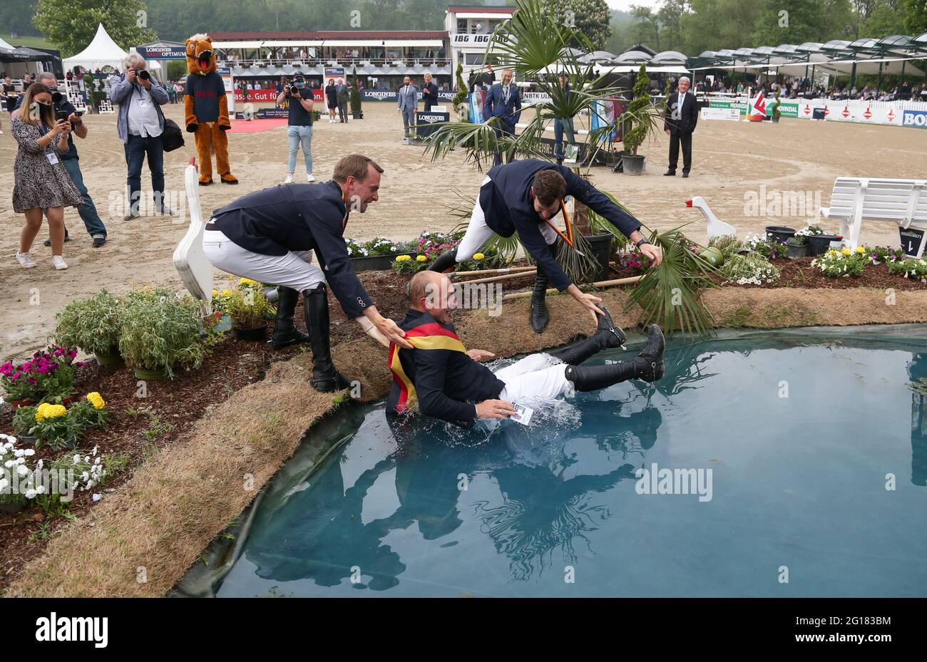 Balve, Germany. 05th June, 2021. Equestrian sport: German Championship, Show Jumping. The show jumper Tobias Meyer (M) celebrates winning the German Show Jumping Championship with the second placed Maximilian Weishaupt (r) and the third placed Patrick Stühlmeyer. Credit: Friso Gentsch/dpa/Alamy Live News Stock Photo