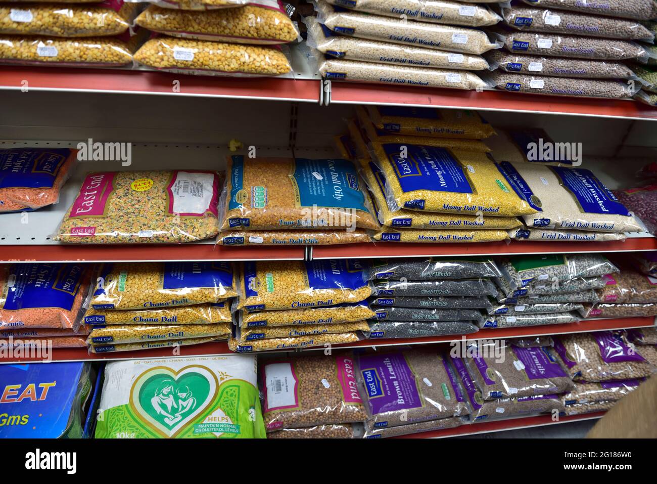 Shelves full of bags of dried lentils and beans in small local well stocked corner grocery shop, UK Stock Photo