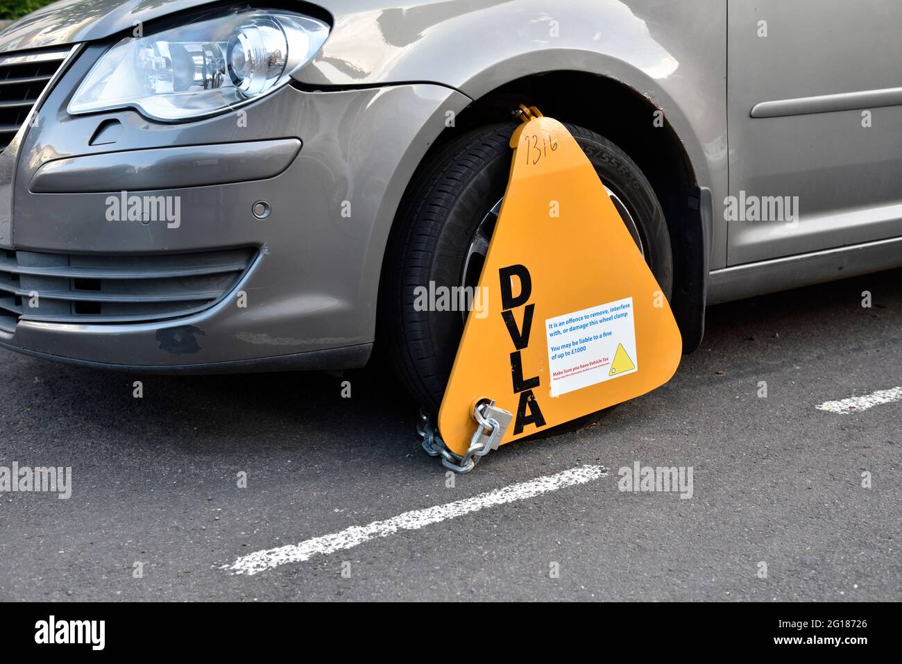 DVLA wheelclamp on front wheel of parked car, UK Stock Photo