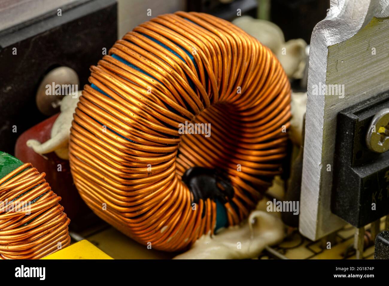 An inductor, toroidal coil on a ring with visible copper scroll, wound