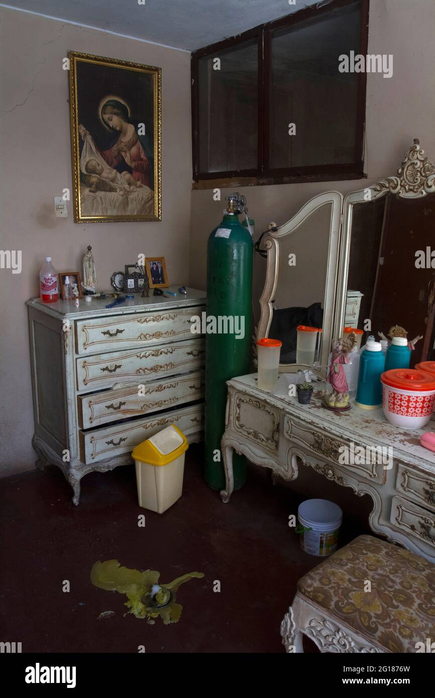 An oxygen balloon, a serum bag, alcohol and bootles of water decorate the bedroom of María Jiménez Amado (65). During 2021, 11% of all covid-19 deaths in Lima (Perú) occurred at home. According to the Peruvian government 185,380.00 people have died due to the coronavirus across the country. Peru. Stock Photo